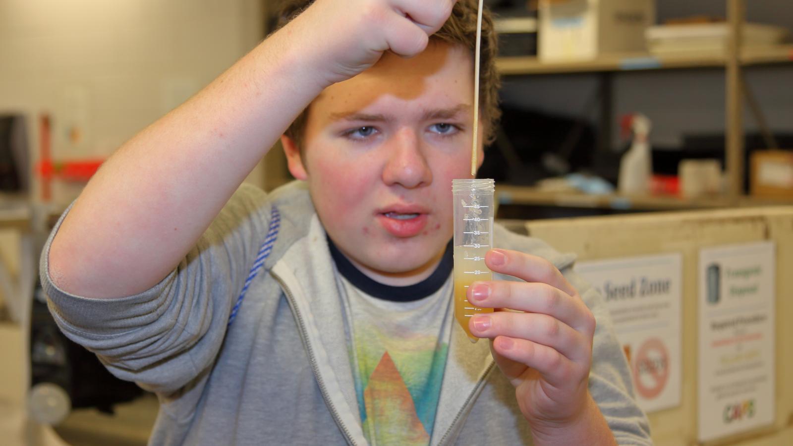 A middle school student extracts DNA from applesauce during a field trip